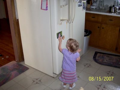 small girl in front of refrigerator