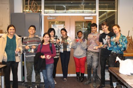 Students posing with booties they made for the exhibit