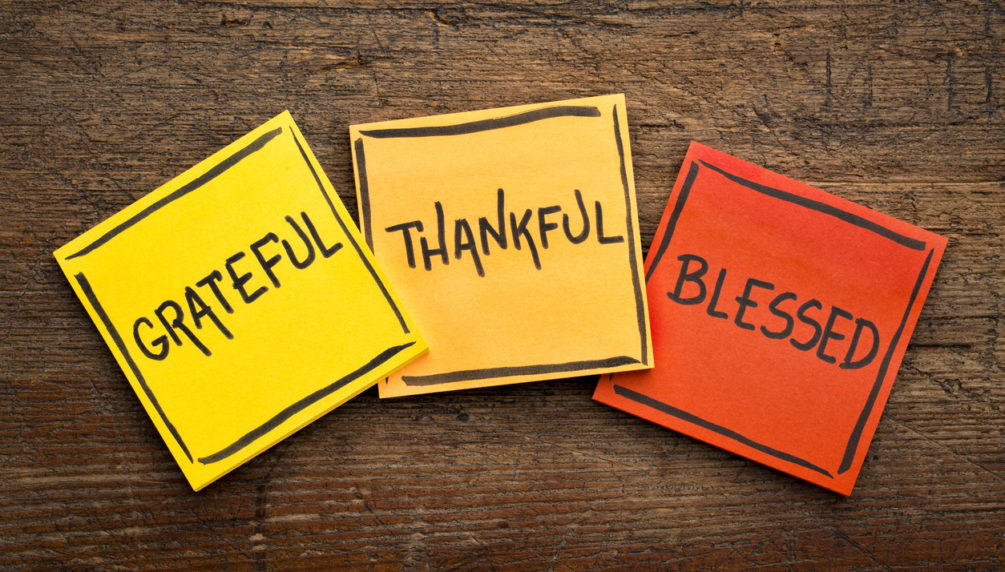 Grateful, thankful, blessed spiritual words - handwriting in black ink on sticky notes against rustic wood