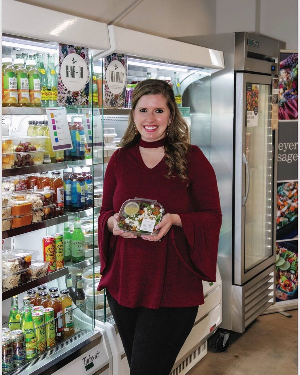 Callie standing in front of the grab'n'go section at Meyer and Sage